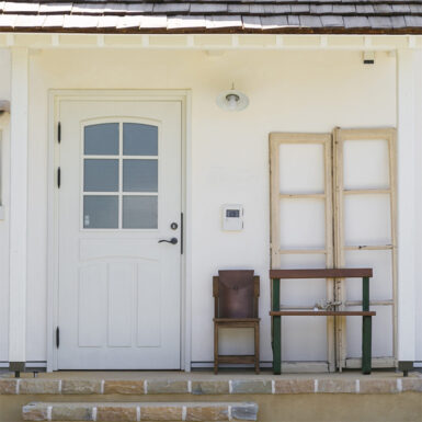 漆喰壁と白いドアが印象的な家の外観